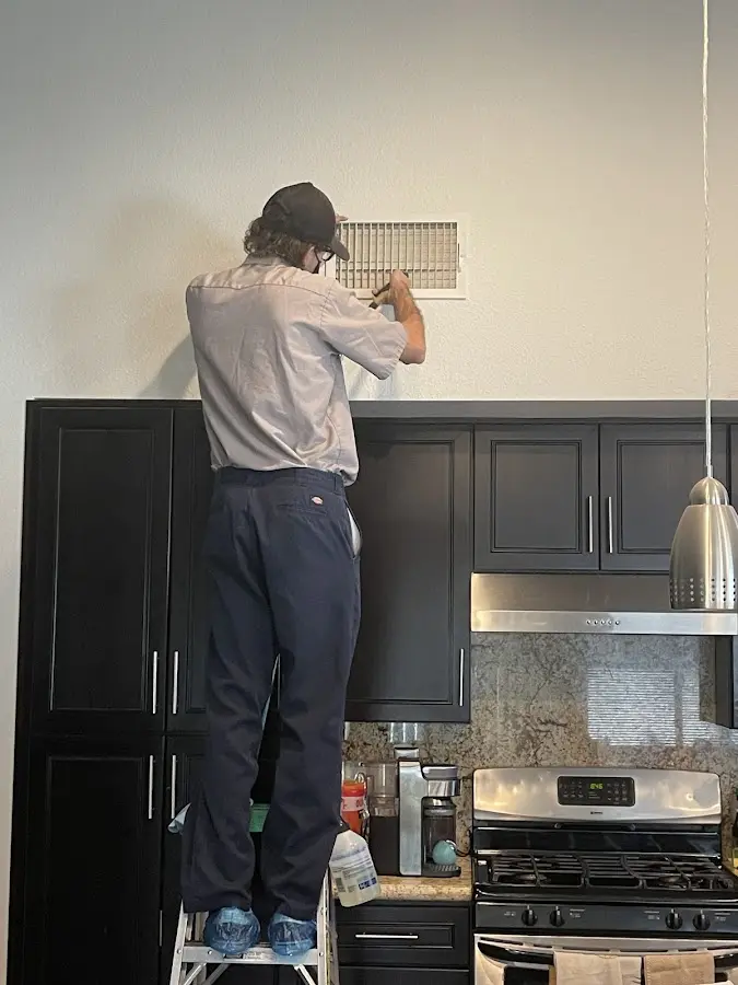 Technician inspecting an air vent during HVAC service in Bealeton